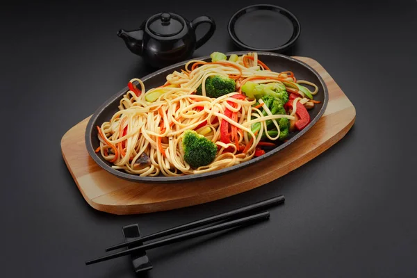 アジア食品。黒いテーブルの上の野菜入りうどん. — ストック写真