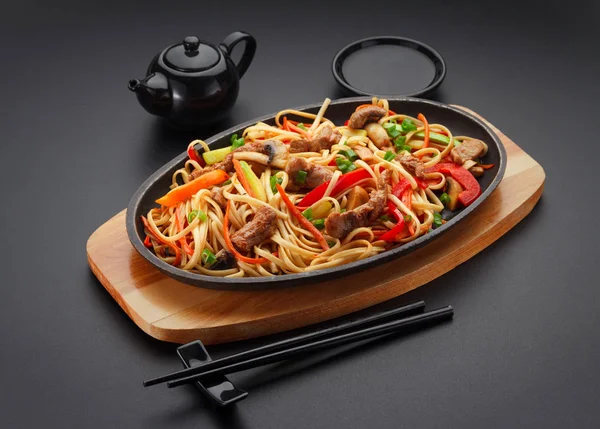 Comida asiática. Macarrão Udon com carne de porco na mesa preta . — Fotografia de Stock