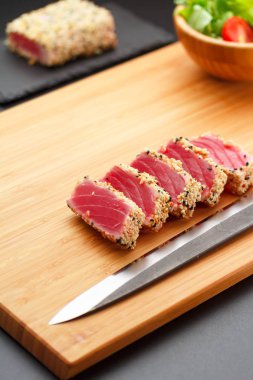 Bir ahşap tahta üzerinde ızgara ton balığı filetosu.