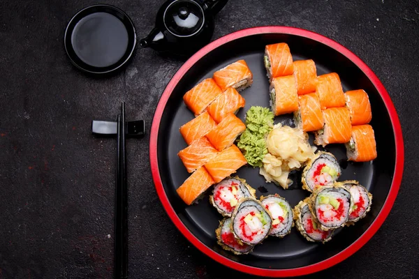 Japanska köket. Sushi rulle med färska råvaror på en sten tallrik och bakgrund. — Stockfoto
