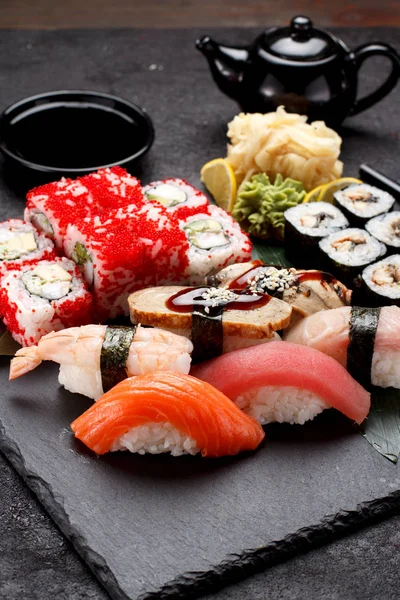 Cozinha japonesa. Sushi definido em uma placa de pedra e fundo de concreto . — Fotografia de Stock