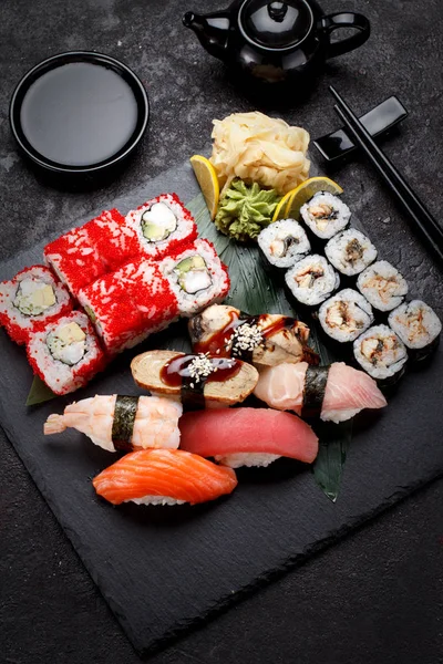 Cozinha japonesa. Sushi definido em uma placa de pedra e fundo de concreto . — Fotografia de Stock