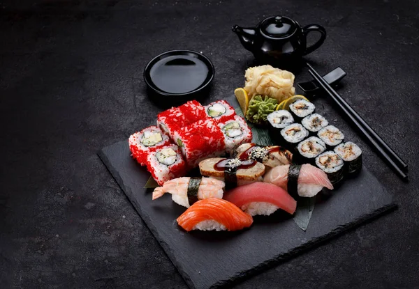 Cozinha japonesa. Sushi definido em uma placa de pedra e fundo de concreto . — Fotografia de Stock