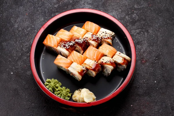 Japanska köket. Sushi rulle set på en runda träplatta och mörk konkreta bakgrund. — Stockfoto