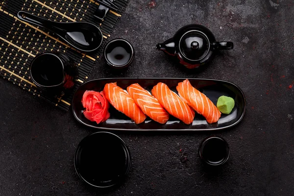 Japanska köket. Lax sushi (nigiri) på en svart plåt och mörk konkreta bakgrund. — Stockfoto