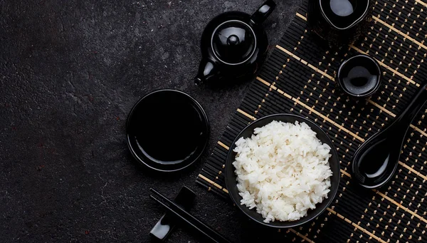 Cocina japonesa. Arroz para sushi en un plato negro y fondo de hormigón oscuro . — Foto de Stock