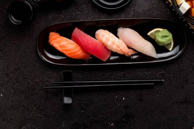 Suşi karanlık beton arka plan üzerinde siyah plaka ve miso çorbası ayarla