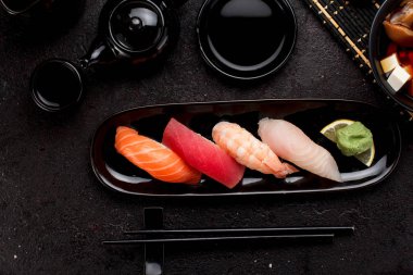 Suşi karanlık beton arka plan üzerinde siyah plaka ve miso çorbası ayarla