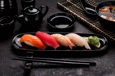 Suşi karanlık beton arka plan üzerinde siyah plaka ve miso çorbası ayarla