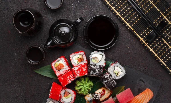 Japanska köket. Sushi på en sten tallrik och svart betong bakgrund. — Stockfoto