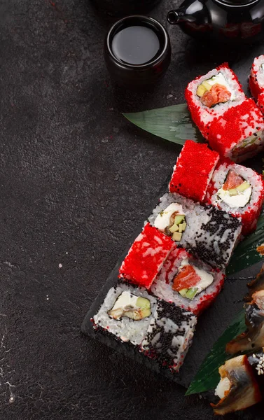 Japon mutfağı. Suşi bir taş plaka ve siyah beton zemin üzerinde ayarla.