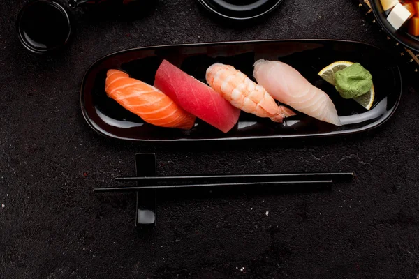 Suşi karanlık beton arka plan üzerinde siyah plaka ve miso çorbası ayarla