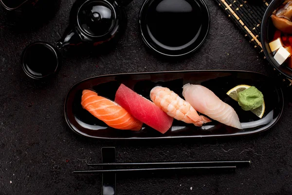 Suşi karanlık beton arka plan üzerinde siyah plaka ve miso çorbası ayarla