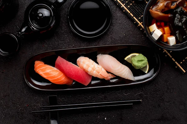 Suşi karanlık beton arka plan üzerinde siyah plaka ve miso çorbası ayarla