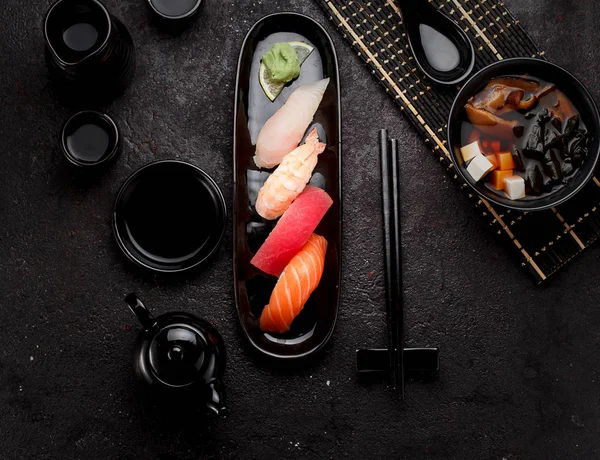 寿司の暗いコンクリート背景を黒プレートと味噌スープのセット — ストック写真