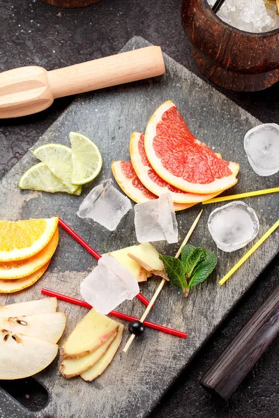 Coconut with ice and fresh fruits (grapefruit, kiwi, orange ) and mint over concrete background. — Stock Photo, Image