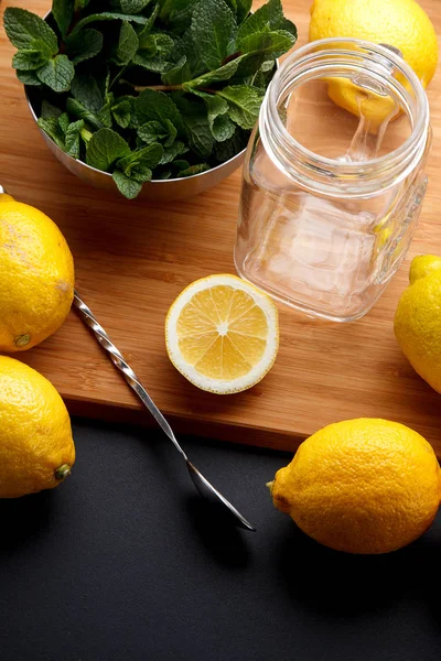 El limón amarillo fresco está listo para el jugo en una mesa negra — Foto de Stock