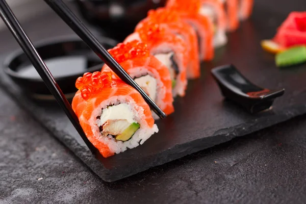 Japanska köket. Sushi rulle över konkreta bakgrund. Stockbild