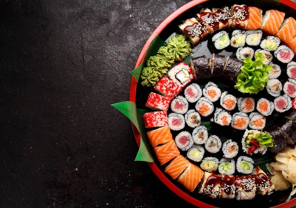 Japonská kuchyně. Suši uprostřed kruhové desky nad konkrétní pozadí.. — Stock fotografie