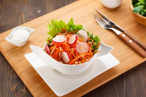 Insalata di verdure su un piatto bianco, bordo di legno e sfondo . — Foto Stock