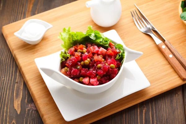 Vinagreta sobre un plato blanco, tablero de madera y fondo . — Foto de Stock