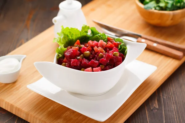 Vinagreta sobre un plato blanco, tablero de madera y fondo . —  Fotos de Stock