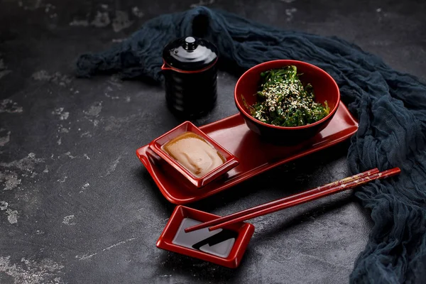 Chuka with nut sauce and chopsticks over dark concrete background — Stock Photo, Image
