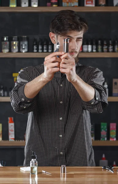 Vape. Seorang pria di sebuah bar vape (toko) sedang memperbaiki e-rokok . — Stok Foto