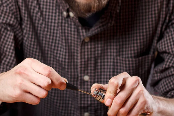 Vape. Un hombre en una barra de vapor (tienda) está reparando el cigarrillo electrónico . — Foto de Stock