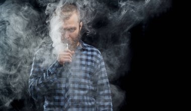 Bir mod tutarak Vaping adam. Buhar bulutu. Siyah arka plan. Stüdyo çekim.
