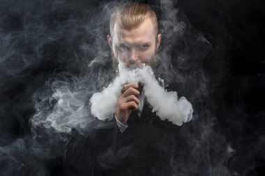 Bir mod tutarak Vaping adam. Buhar bulutu. Siyah arka plan. Stüdyo çekim.