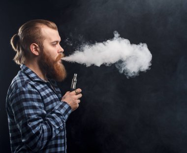 Bir mod tutarak Vaping adam. Buhar bulutu. Siyah arka plan. Stüdyo çekim.