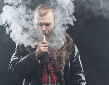 Bir mod tutarak Vaping adam. Buhar bulutu. Siyah arka plan. Stüdyo çekim.