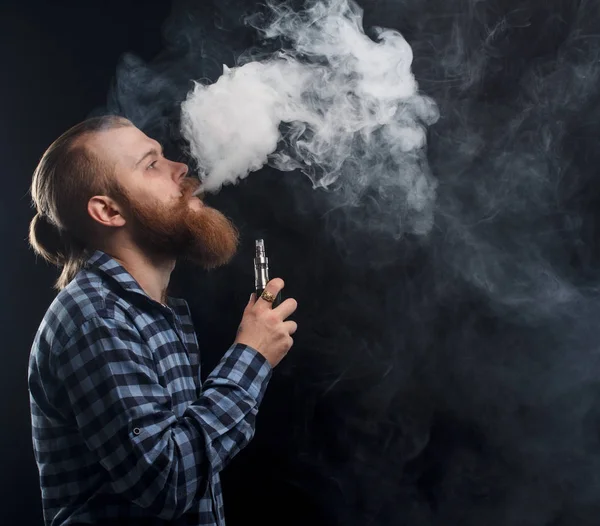 Bir mod tutarak Vaping adam. Buhar bulutu. Siyah arka plan. Stüdyo çekim.