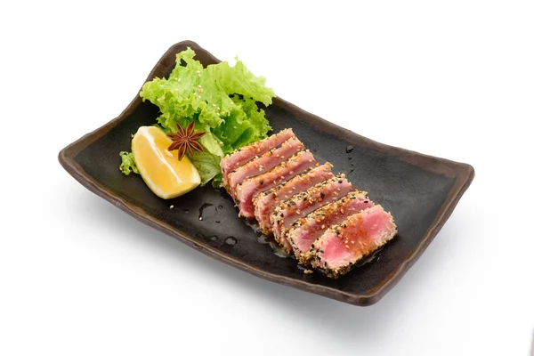 Tataki (filet de thon) sur une plaque noire isolée sur fond blanc , — Photo