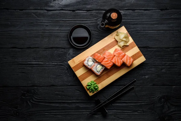 Японская кухня. Лосось суши ролл (Филадельфия) на темном деревянном фоне — стоковое фото