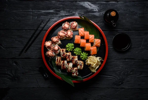 Japonská kuchyně. Sushi set na kruhové desky nad tmavé dřevěné pozadí. — Stock fotografie