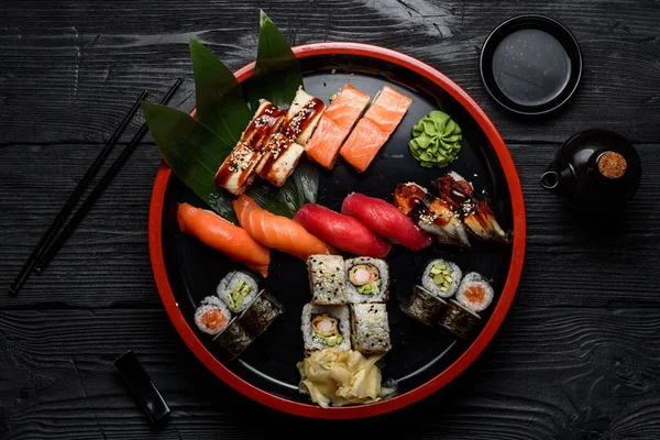Japon mutfağı. Sushi yuvarlak tabağa koyu ahşap arka plan üzerinde ayarla.