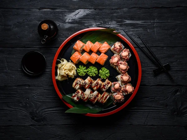 日本料理。在黑暗的木制背景设置在一个圆盘上的寿司. — 图库照片