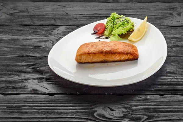 Koyu ahşap arka plan üzerinde ızgara balık fileto