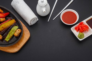 Soya sosu zencefil ve wasabi karanlık tablo üzerinde sebzeler ile.