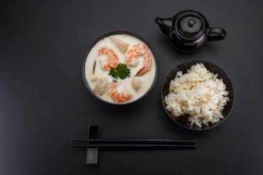 Koyu arka plan üzerinde deniz ürünleri ile Tom kha çorbası.