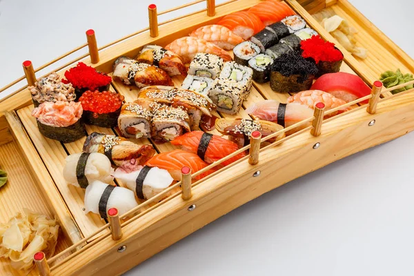 Sushi auf einem Holzteller vor weißem Hintergrund. — Stockfoto