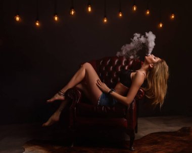 Vaping seksi bir kadındır. Stüdyo çekim.