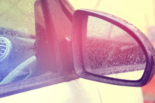 Smart car mirror. Raindrops. Black and white mini car.