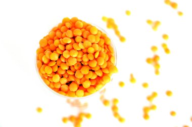 Beyaz arka planda kırmızı mercimek. Bir avuç dolusu baklagil.