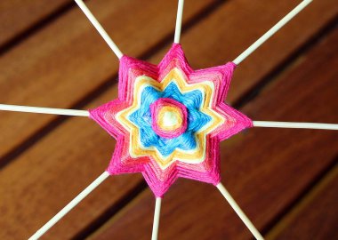 Ahşap kürdandaki mavi iplikten yapılmış hasır mandala. Çiçek ya da yıldız deseni.