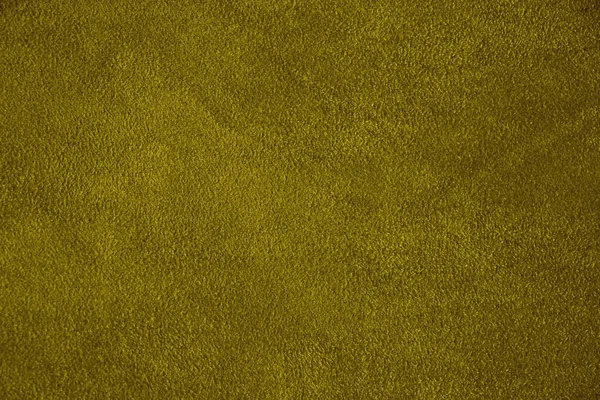 The texture of genuine suede. Green background.