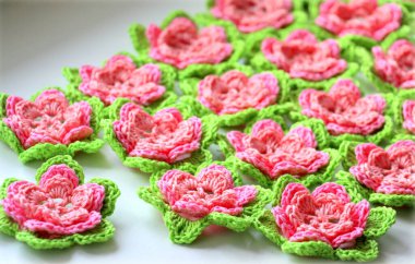 Yeşil yapraklı pembe işlemeli çiçekler..