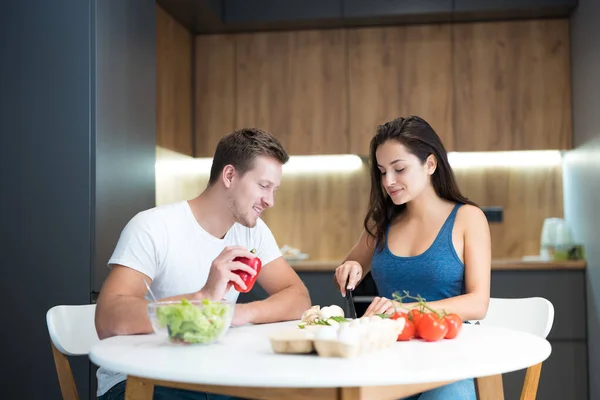 Ung par stilig make och hans vackra fru matlagning frukost i köket tillsammans familjetraditioner — Stockfoto